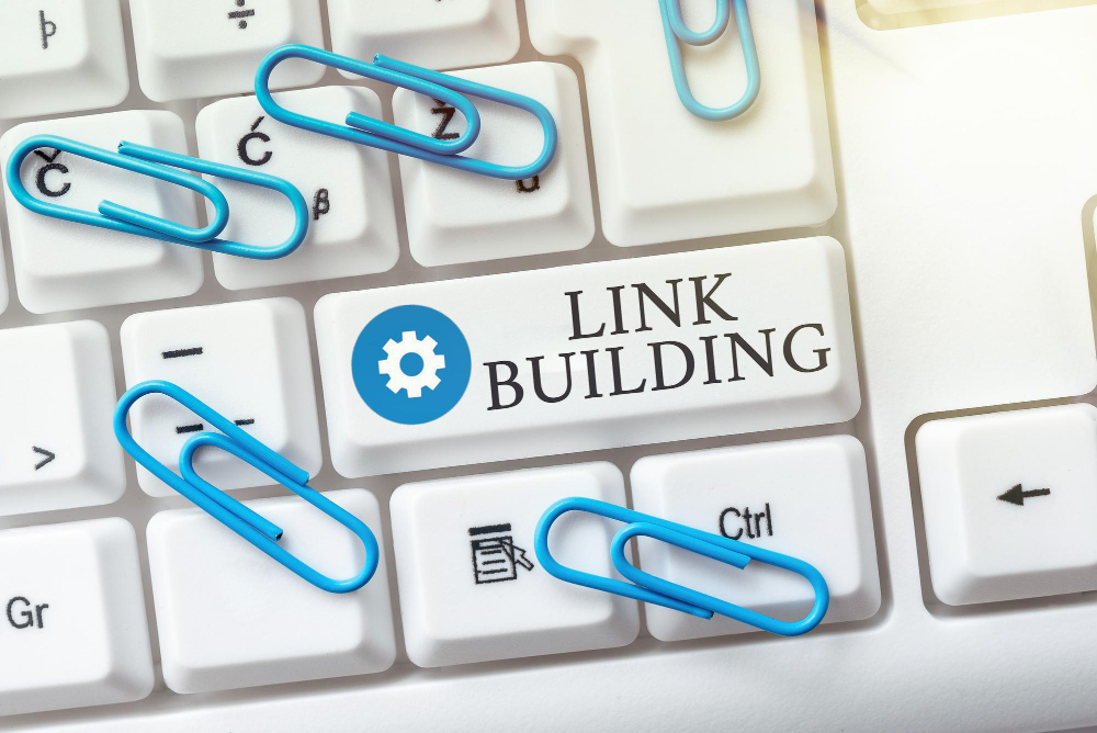 Close-up of a keyboard with a key labeled with Link Building and paper clips around it 